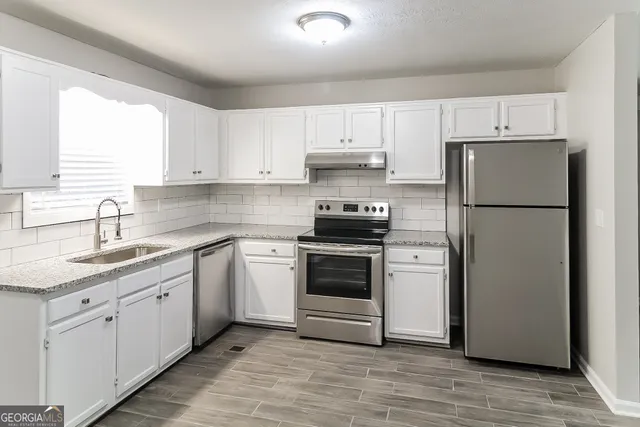 a kitchen with cabinets appliances and a window