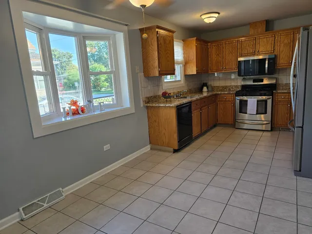 a kitchen with stainless steel appliances a stove a sink and a microwave