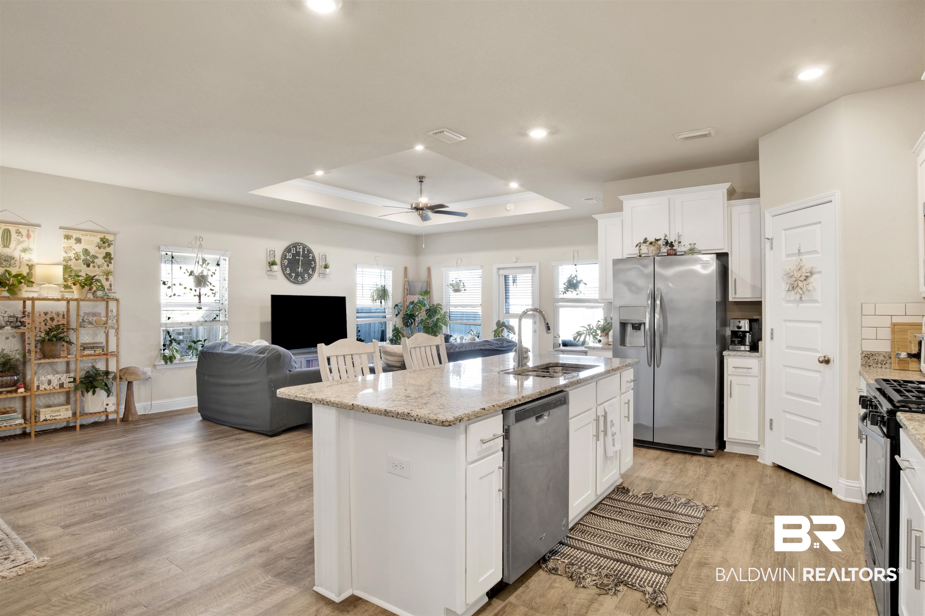 9622 Volterra Avenue Daphne, AL 36526 - Photo 5 of 31 Kitchen with sink, ceiling fan, an island with sink, a tray ceiling, and stainless steel appliances