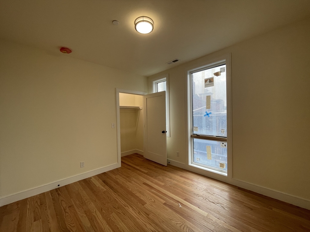 65 Cameron Street, Unit 4 Brookline, MA 02445 - Photo 11 of 13 an empty room with wooden floor and windows