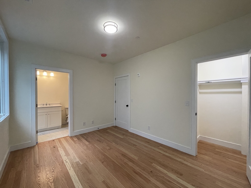 65 Cameron Street, Unit 4 Brookline, MA 02445 - Photo 5 of 13 an empty room with wooden floor and windows
