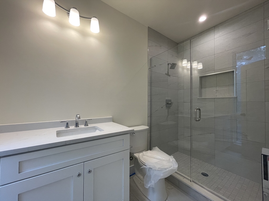65 Cameron Street, Unit 4 Brookline, MA 02445 - Photo 6 of 13 a bathroom with a sink a toilet and shower