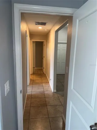 an empty room with wooden floor and fan