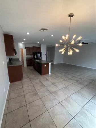 a kitchen with kitchen island granite countertop a stove a sink a microwave a counter top and cabinets