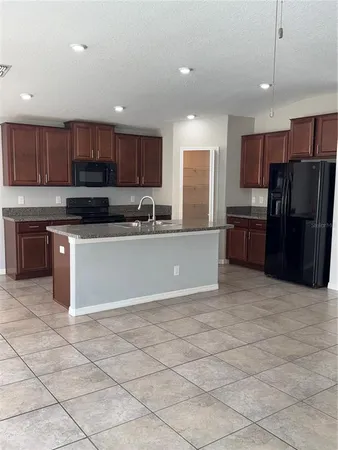 a kitchen with granite countertop a cabinets and a stove top oven