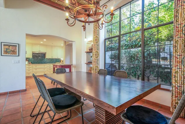 a dining room with wooden floor and large windows