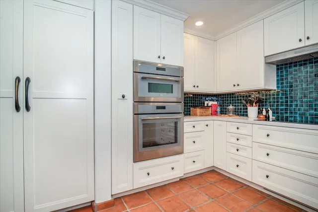 a kitchen with white cabinets and white appliances