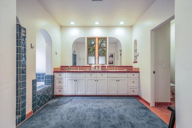 a bathroom with double vanity and a mirror