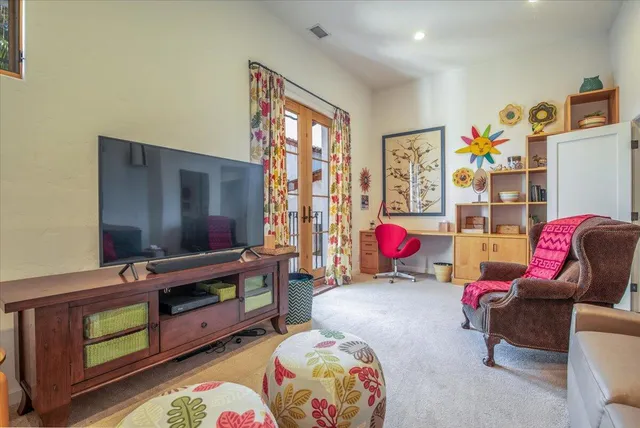 a living room with furniture a flat screen tv and a window