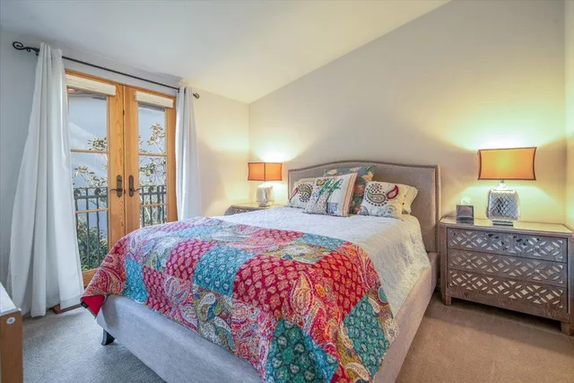 a bedroom with a bed lamp and a window