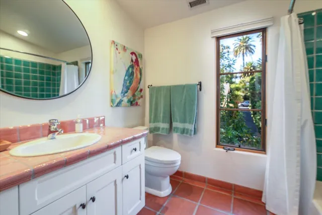 a bathroom with a sink a toilet and a mirror