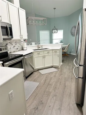 a kitchen with a sink appliances and cabinets