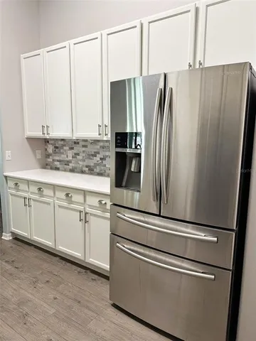a kitchen with stainless steel appliances white cabinets and wooden floors