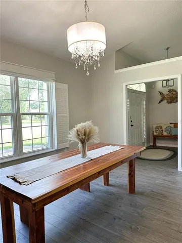 a room with chandelier table and windows
