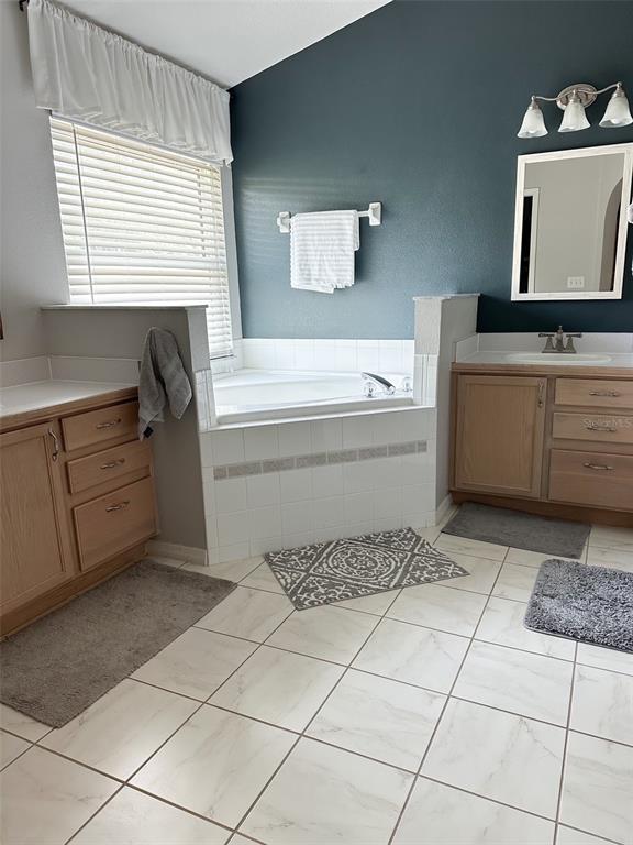 33632 Wesley Road Eustis, FL 32736 - Photo 21 of 34 a bathroom with a bathtub sink and vanity
