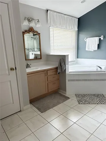 a bathroom with a bathtub sink and mirror