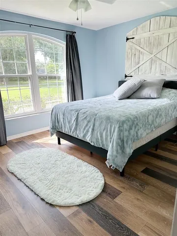 a bedroom with a bed and wooden floor