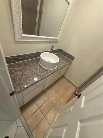 a kitchen with granite countertop a refrigerator and a sink