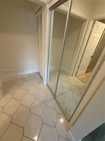 a view of a big room with windows and chandelier fan