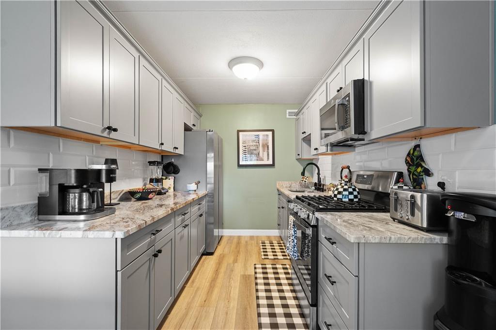 1150 Bower Hill Road, Unit 514B Pittsburgh, PA 15243 - Photo 16 of 44 a kitchen with stainless steel appliances granite countertop a sink stove and refrigerator