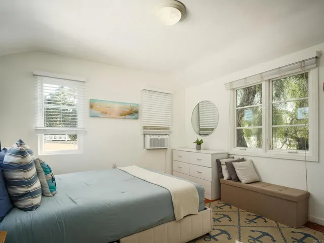 a bedroom with a bed and window with chair