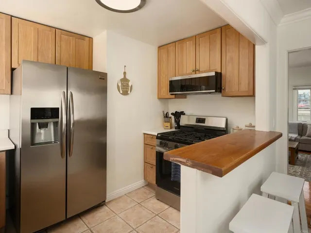 a kitchen with stainless steel appliances granite countertop a refrigerator a stove a sink and a microwave