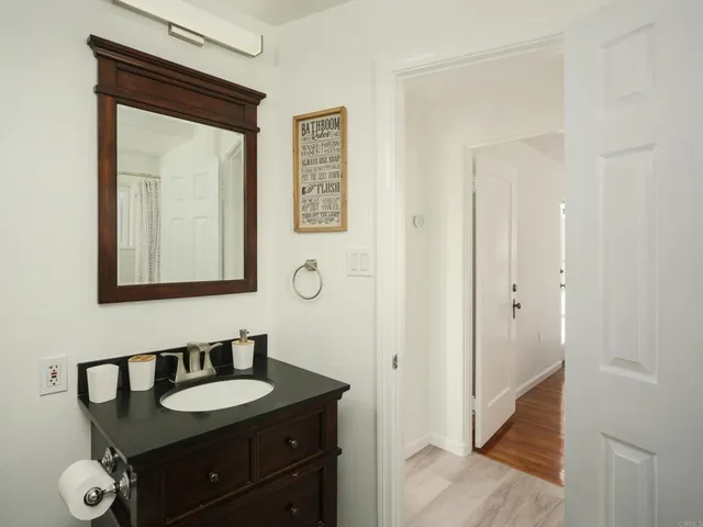 a bathroom with a granite countertop sink and a mirror
