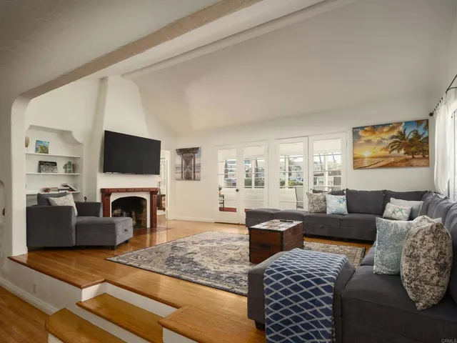 a living room with furniture a flat screen tv and a fireplace