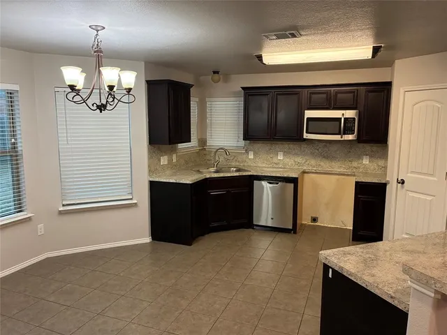 a kitchen with kitchen island granite countertop stainless steel appliances a sink stove and refrigerator