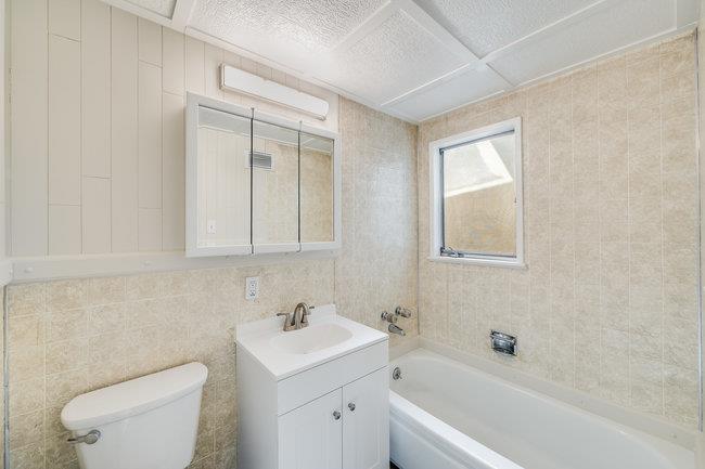 28207 Rochelle Avenue Hayward, CA 94544 - Photo 21 of 27 a bathroom with a toilet a sink a mirror and a bathtub