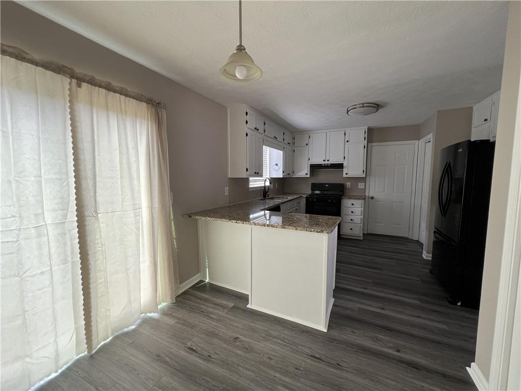 893 Sandune Drive Norcross, GA 30093 - Photo 13 of 14 a kitchen with stainless steel appliances granite countertop a refrigerator a sink dishwasher a stove and white countertops with wooden floor