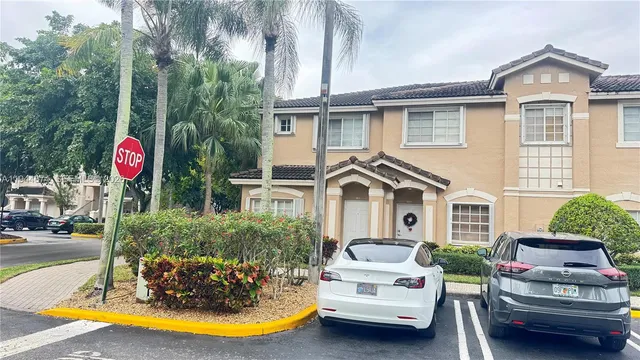 a view of a white house with a swimming pool and porch