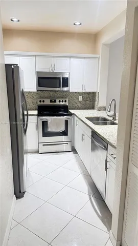 a kitchen with stainless steel appliances a stove a microwave and a sink