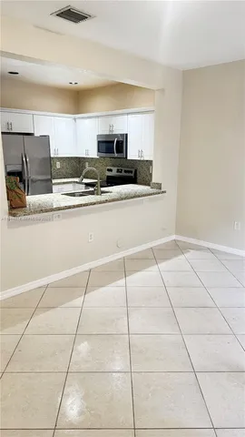 a kitchen with stainless steel appliances a sink a stove a microwave and cabinets