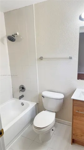 a white toilet sitting next to a bath tub
