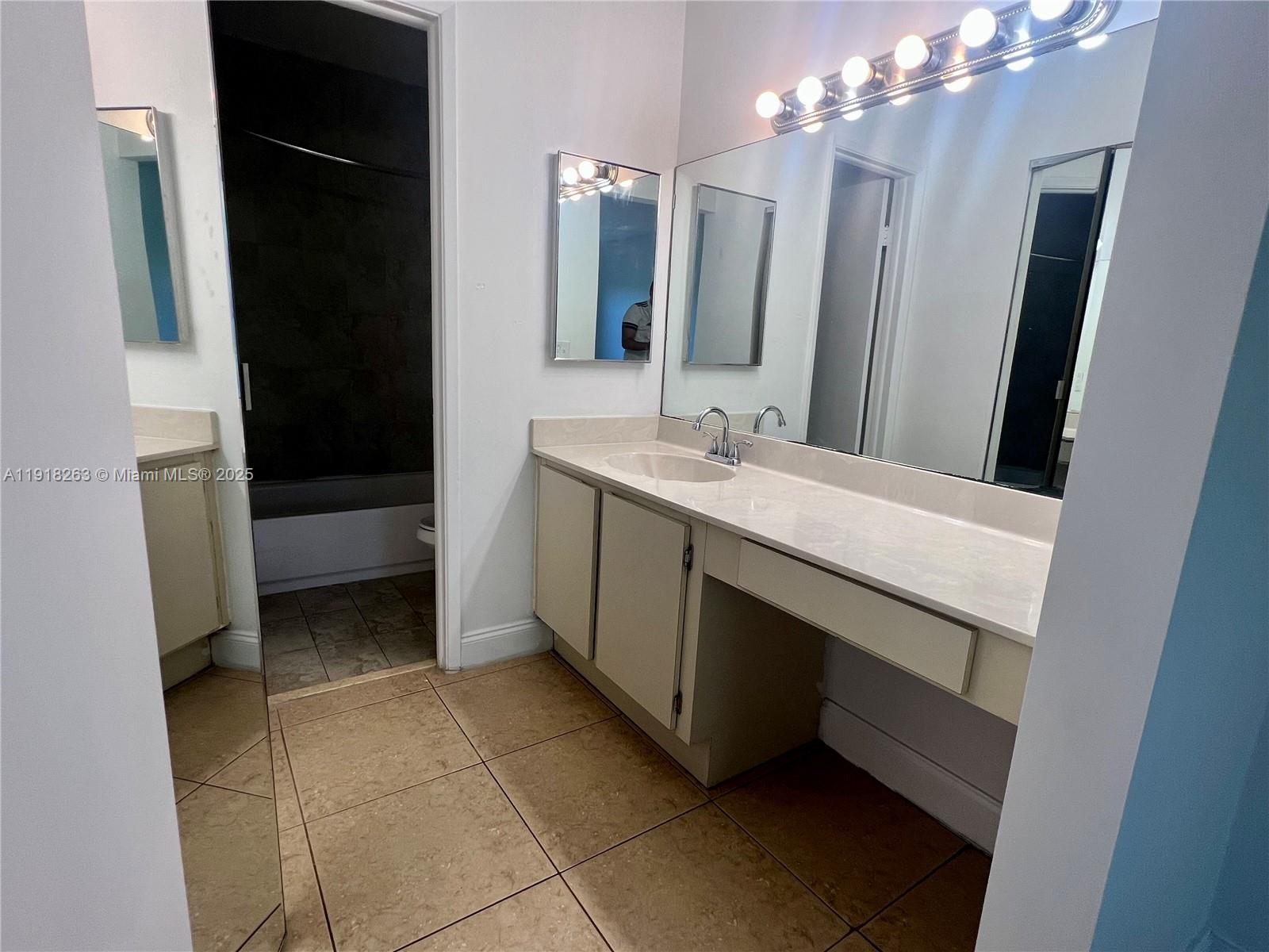 9961 Northwest 9th St Circle, Unit 818 Miami, FL 33172 - Photo 19 of 25 a bathroom with a sink a vanity and a mirror
