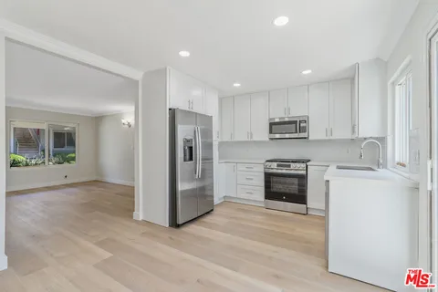 a kitchen with stainless steel appliances a refrigerator stove and sink