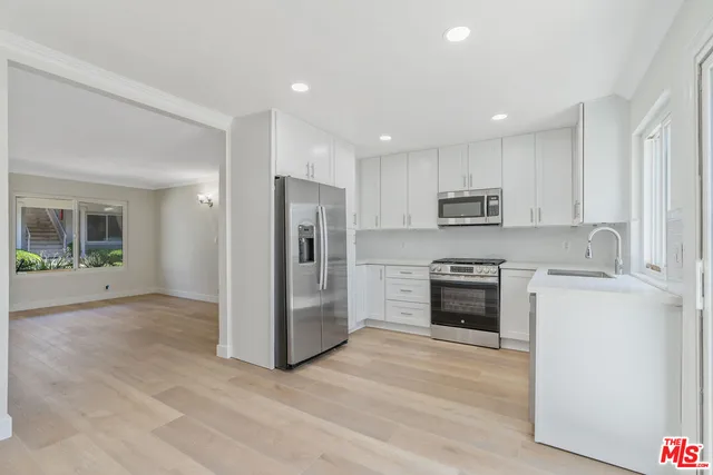 a kitchen with stainless steel appliances a refrigerator stove and sink