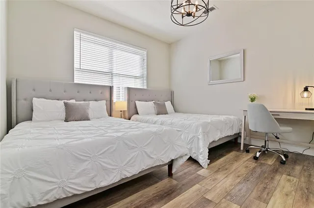 a bedroom with a bed a dresser and chair