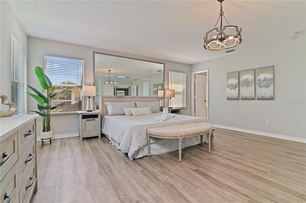 701 Kettering Road Davenport, FL 33897 - Photo 17 of 41 a spacious bedroom with a bed and a chandelier