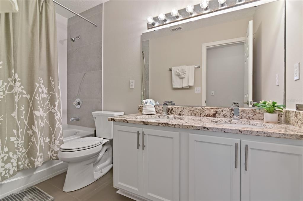 701 Kettering Road Davenport, FL 33897 - Photo 22 of 41 a bathroom with a granite countertop sink toilet and mirror