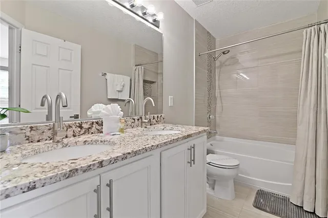 a bathroom with a granite countertop sink a toilet and shower