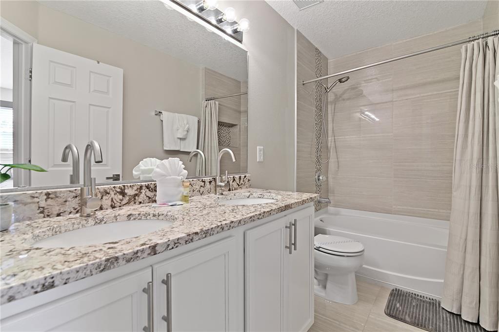 701 Kettering Road Davenport, FL 33897 - Photo 26 of 41 a bathroom with a granite countertop sink a toilet and shower