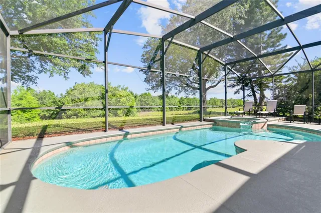 a view of a swimming pool with a yard and plants