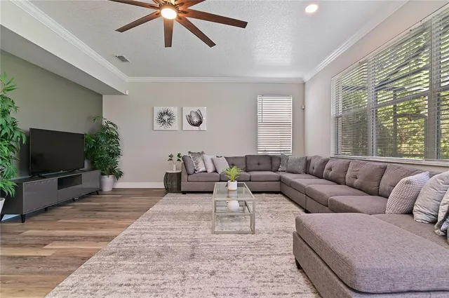 a living room with furniture a flat screen tv and a large window
