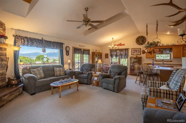 a living room with furniture kitchen view and a large window