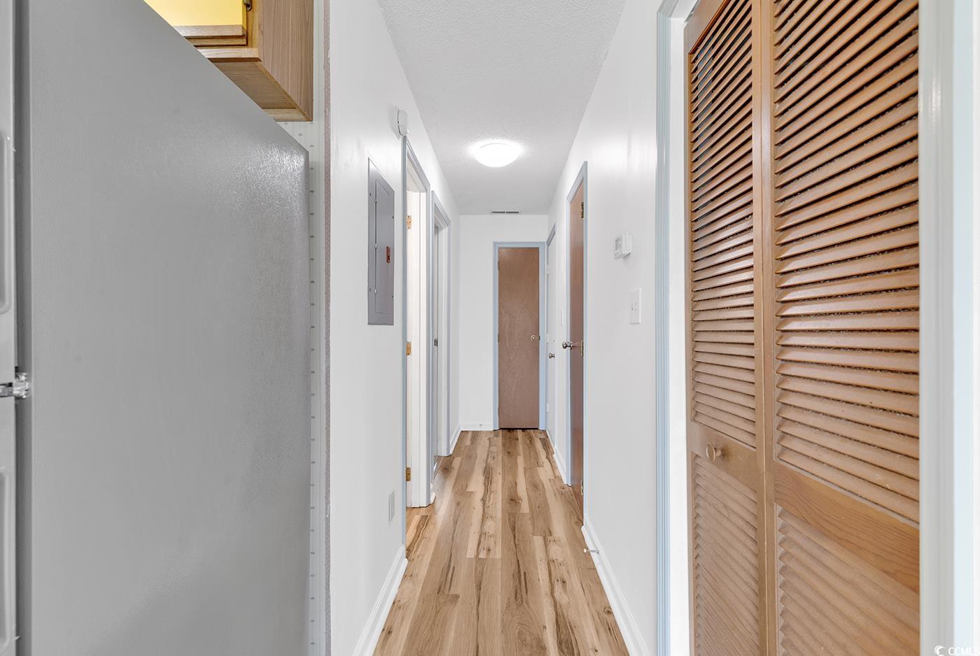3700 Golf Colony Lane, Unit 25G Little River, SC 29566 - Photo 3 of 18 Hall featuring a heating unit, light wood finished floors, baseboards, and electric panel