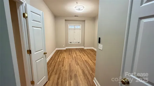 a view of a hallway with wooden floor and closet
