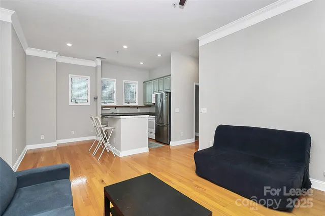 a living room with furniture and a refrigerator