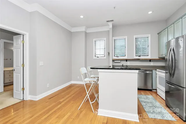 a kitchen with stainless steel appliances granite countertop a sink a stove a refrigerator and island